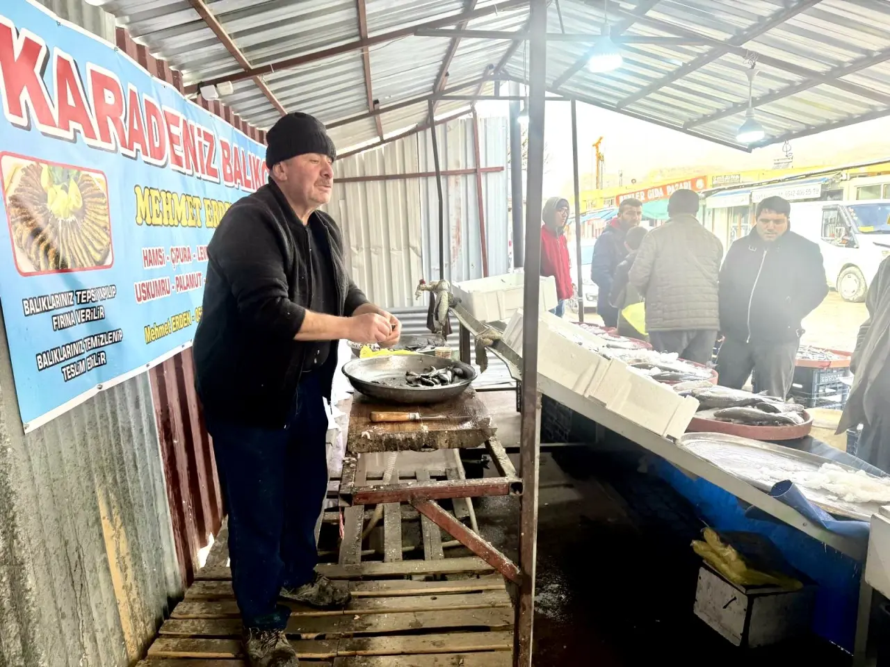 İşletmeci Mehmet Erden'in tezgahta taze balıkları temizleyerek satışa hazırlaması
