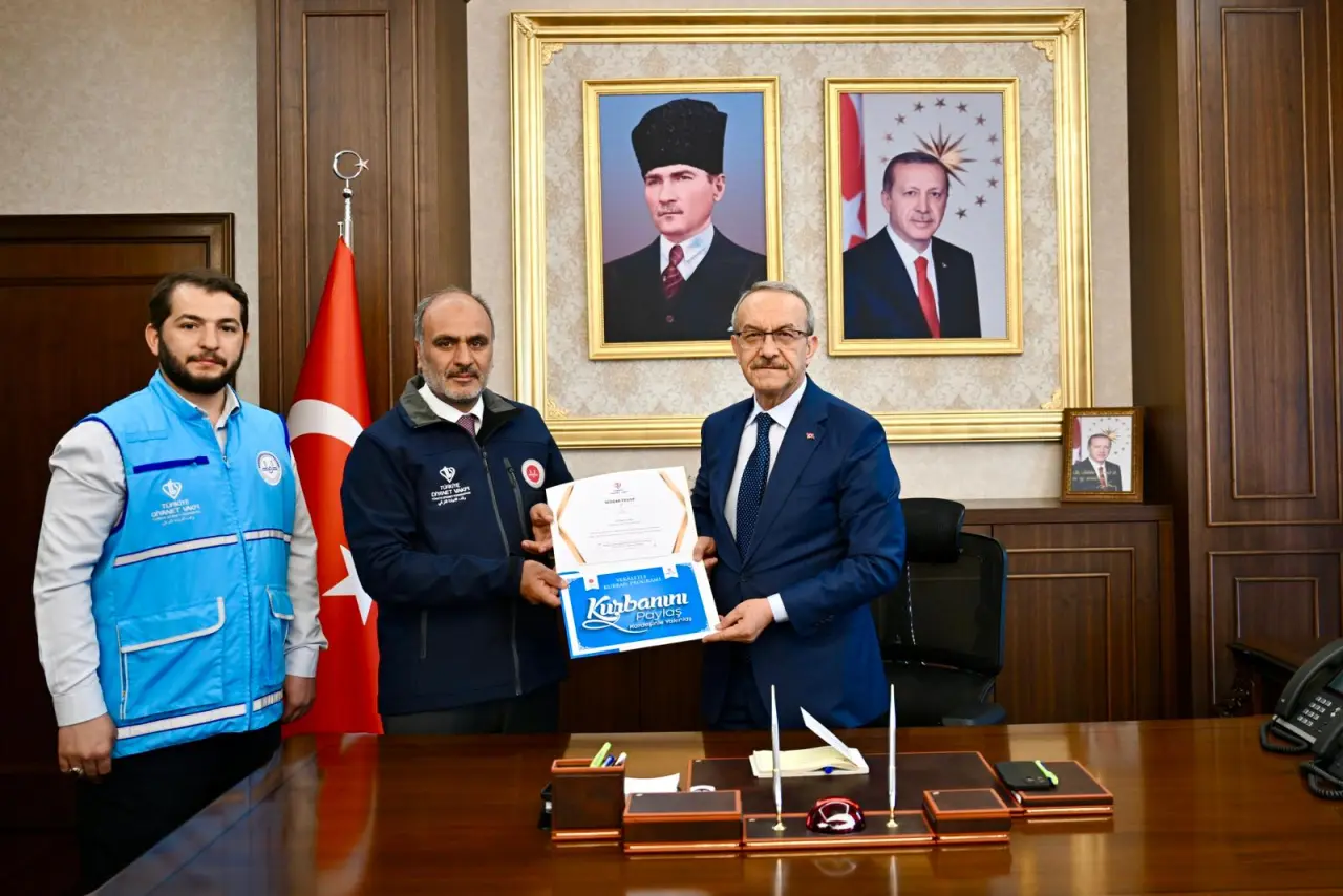 Malatya Valisi Seddar Yavuz'un, İl Müftüsü Ramazan Dolu'ya Türkiye Diyanet Vakfı'nın 2026 yılı vekaletle kurban organizasyonu kapsamında bağış makbuzunu teslim ettiği an.