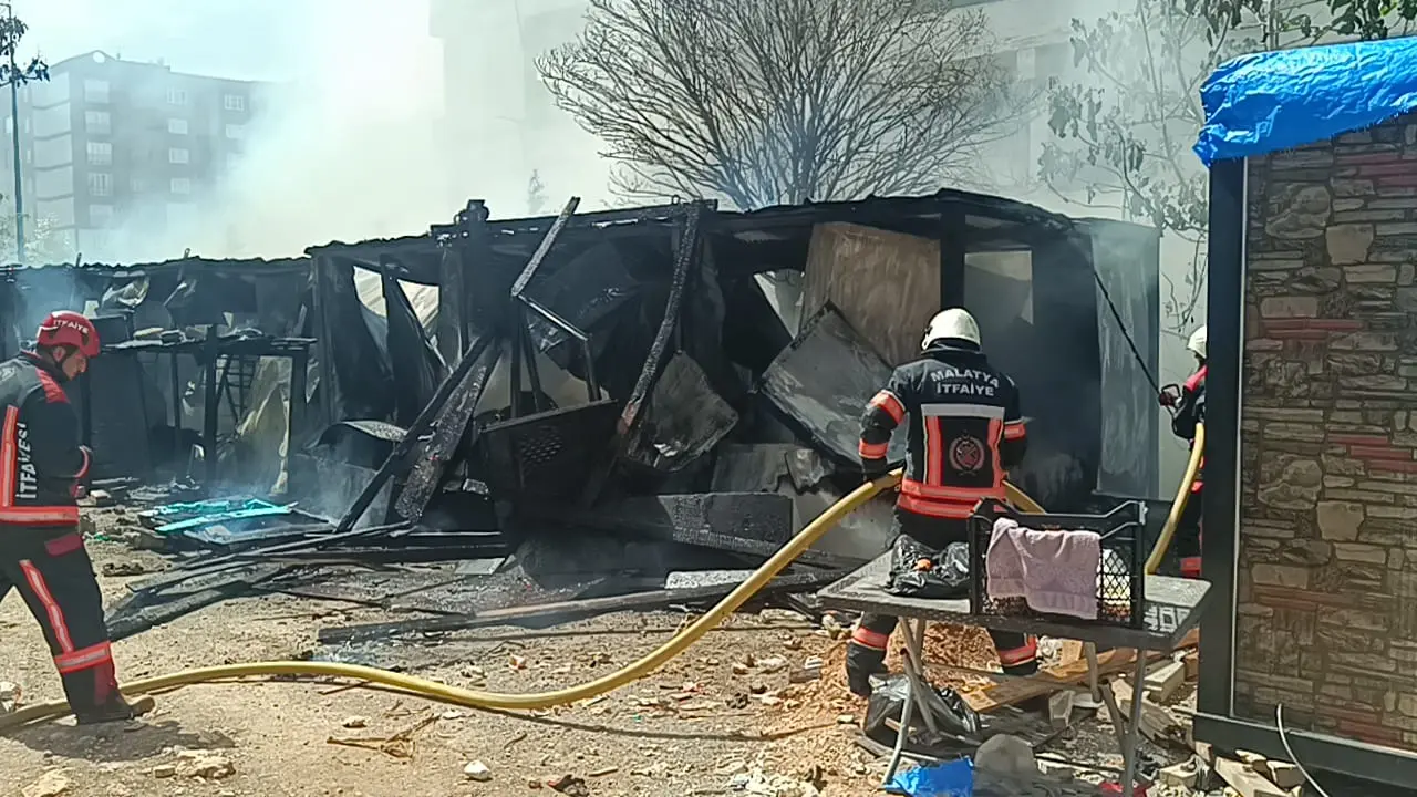 Malatya'nın Yeşilyurt ilçesi Bostanbaşı Mahallesi'ndeki bir şantiyede işçilerin barınmak için kullandığı ve çıkan yangın sonucu tamamen küle dönen konteynerlere itfaiye ekiplerinin müdahale ettiği anları gösteren bir kare.